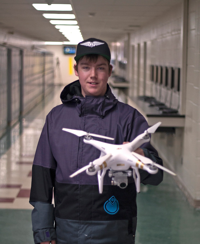 Student holding drone with camera