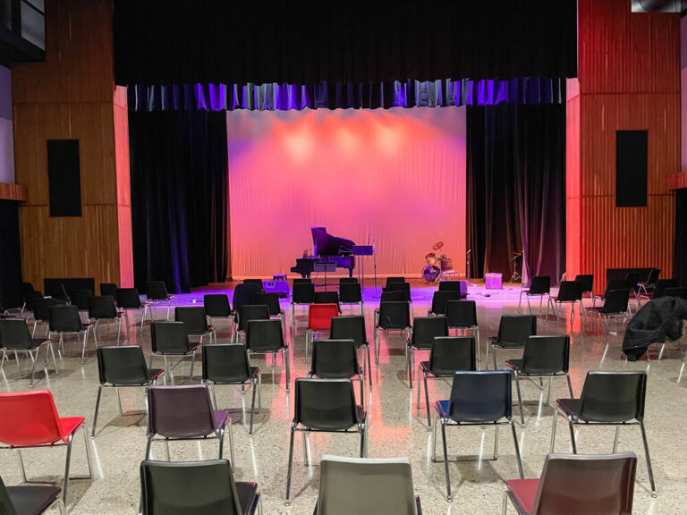 stage set up with piano and theatre lighting