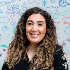 Photo of a woman smiling in front of a colourful background