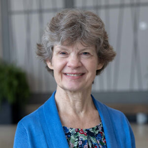 Photo of a woman smiling wearing a blue cardigan