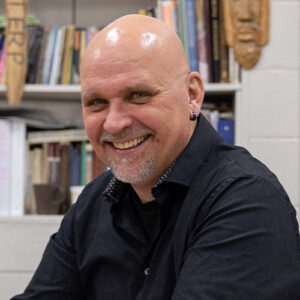 Photo of a man smiling in a dark shirt